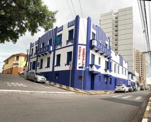 a blue and white building on the side of a street at Hotel Carvalho in Bragança Paulista
