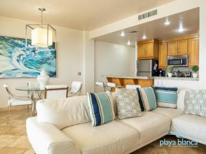 Una sala de estar con un sofá blanco y una cocina. en Playa Blanca Premier Unit 504, en Isla Venado