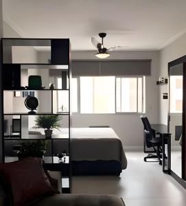 a bedroom with a bed and a desk and a chair at Lindo Apto Beira Mar - Ponta da Praia - Santos in Santos