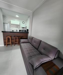 a living room with a couch and a kitchen at Lindo Apto Beira Mar - Ponta da Praia - Santos in Santos