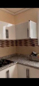 a kitchen with white cabinets and a counter top at Apparemment RDC AL HOCEIMA in Al Hoceïma