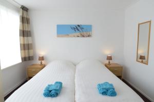 a bedroom with a bed with blue towels on it at Logies De Sering Texel in De Koog
