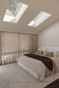 a bedroom with a large bed with skylights at The Ambers at Port Stephens in Bobs Farm +54 photos