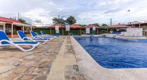 a row of chairs sitting next to a swimming pool at Villas Paraiso B52 in Jacó