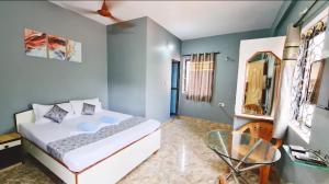 a bedroom with a bed and a glass table at Jacksons Beach House Calangute in Calangute