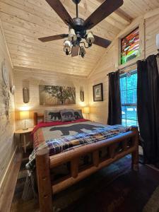 ein Schlafzimmer mit einem Bett und einem Deckenventilator in der Unterkunft The Dapper Duck Log Cabin in Cosby