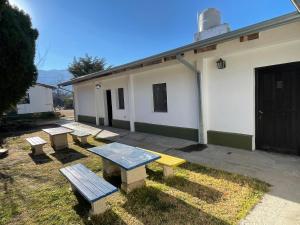 a group of picnic tables in front of a building at Tafi del Valle Hostel in Tafí del Valle