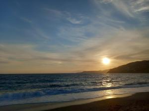 a sunset on the beach with the sun setting at Piso mar in Salobreña +1 photo