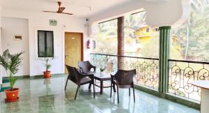 a dining room with a balcony with a table and chairs at Jacksons Beach House Calangute in Calangute