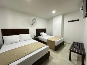 a hotel room with two beds and a table at Santa Elena Hotel in Ocaña