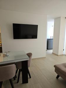 Una sala de estar con una mesa y un televisor en una pared. en Cozy Apt In The Coffee Region, en Armenia