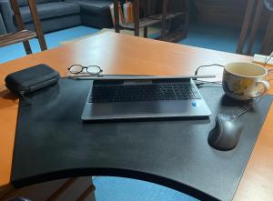 a laptop computer on a table with a cup of coffee at Lovely house with garden Paris Flea Market in Saint-Ouen