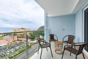 ein Balkon mit Stühlen und Blick auf die Stadt in der Unterkunft Viva Jaco in Jacó + 37 Fotos