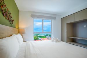 a bedroom with a large white bed and a window at Viva Jaco II in Jacó +48 photos