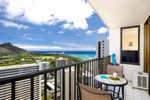 a balcony with a table and chairs and the ocean at 34th floor lanai with Diamond Head views, pool & hot tub access in Honolulu