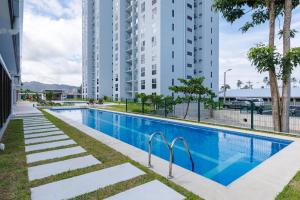 a swimming pool in a building with tall buildings at Viva Jaco II in Jacó
