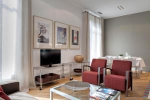 a living room with a couch and a tv at Habitat Apartments Rambla Deluxe in Barcelona