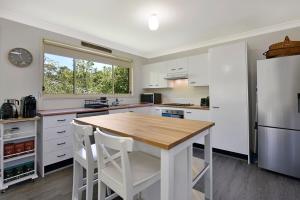 黑荒地4BR 2BA Cozy Blackheath Cottage with Firepit & Pool Table的配有木桌和冰箱的厨房 更多11张照片