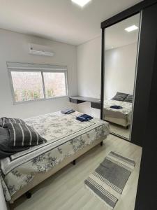 a bedroom with two beds and a large mirror at Espaço Ideal in Passos
