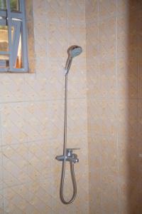 a shower with a shower head in a bathroom at 2 Bedroom Suite with Sitting Area in Kigali +30 photos