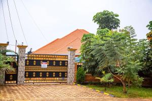 a gate in front of a house with a tree at 2 Bedroom Suite with Sitting Area in Kigali