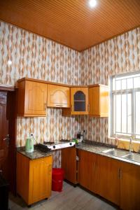 a kitchen with wooden cabinets and a sink and a window at 2 Bedroom Suite with Sitting Area in Kigali