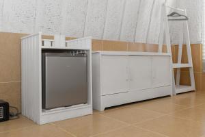 a white kitchen with a counter and a dishwasher at New Life Village in Gili Trawangan