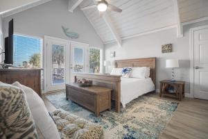 a bedroom with a bed and a couch and windows at Aqua Dreams - Pet Friendly! Heated Private Pool! in Padre Island +61 photos