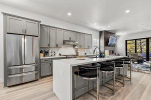a kitchen with gray cabinets and a kitchen island with bar stools at Cottonrose Flagstaff in Flagstaff