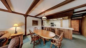 a kitchen and dining room with a wooden table and chairs at Retro 3 Bed 3 Bath Condo with Mountain View! Steps to Canyon Lodge! Unit 210 at 1849 in Mammoth Lakes +43 photos