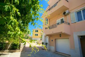 a building with a garage in front of it at Apartments Tomulić in Novalja