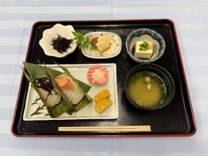 una bandeja negra con un plato de comida y sopa en Hotel Crane Tachibana, en Miyazaki