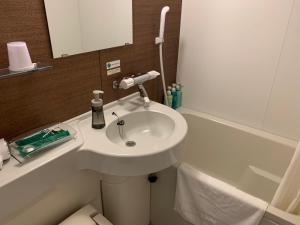 a bathroom with a sink and a bath tub at Hotel Route-Inn Isesaki Inter in Isesaki +22 photos