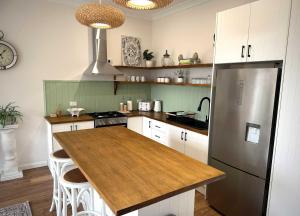 a kitchen with a refrigerator and a wooden counter top at The Summer Cottage in Orange