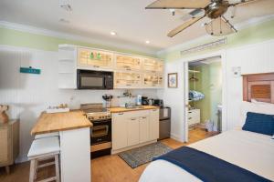 a kitchen with white cabinets and a bed in a room at 521 Sunsuite in Fripp Island