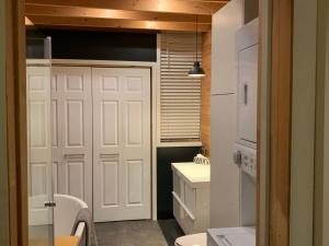 bagno con porta bianca e lavandino di Le loft du capitaine a L'Ange Gardien