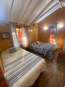 une chambre avec deux lits dans une pièce dans l'établissement Cabaña Parcela Nativo, à Los Álamos 33 autres photos