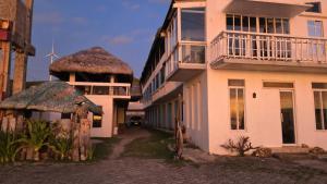 un edificio con techo de paja al lado de una calle en Sea Breeze Beach Resort, en Mabubua