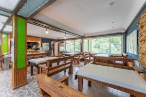 a dining room with wooden tables and benches at Sangol Story Pension in Samgyo-ri