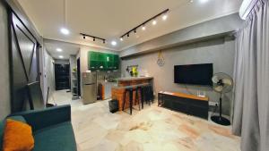 a living room with a kitchen with green cabinets at 10pax GFloor 2R2B DUAL-KEY SEASIDE, WATERSPORT, FREE BBQ Set, Pool, Wifi, 50"TV in Port Dickson