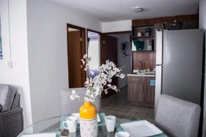 a kitchen with a glass table with a vase with flowers at Moderno Departamento 2 Centro Historico - Modern Apartment 2 Downtown in San Luis Potosí