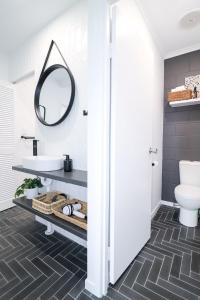 a bathroom with a sink and a mirror at Whitsunday Pandanus-Stylish 2 bedroom townhouse in quiet location in Cannonvale