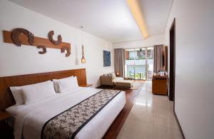 a bedroom with a bed and a living room at MERUSAKA Nusa Dua in Nusa Dua