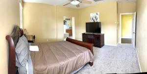 a bedroom with a bed and a flat screen tv at la paz private room with jacuzi in Fresno