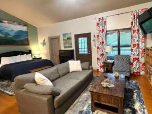 ein Wohnzimmer mit einer Couch und einem Bett in der Unterkunft Super Cute! Hot Tub, Fully Stocked, Great Location in Glade + 26 Fotos