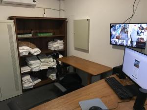 a room with a desk with a computer monitor and a room with a closet at Ô de casa hostel in Balneário Camboriú