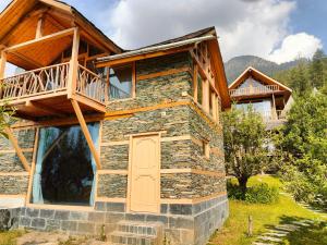 a log home with a balcony and a door at Shantchit Yoga & Wellness Resort Kasol in Jari