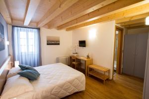 a bedroom with a bed and a desk in it at Hotel All'Arco in Trieste