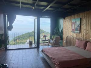 a bedroom with a bed and a balcony with a view at Lego Homestay Tam Đảo Venuestay in Vĩnh Phúc +10 photos