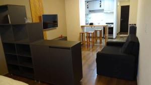 a living room with a couch and a kitchen at Punto733 loft in Trevelín